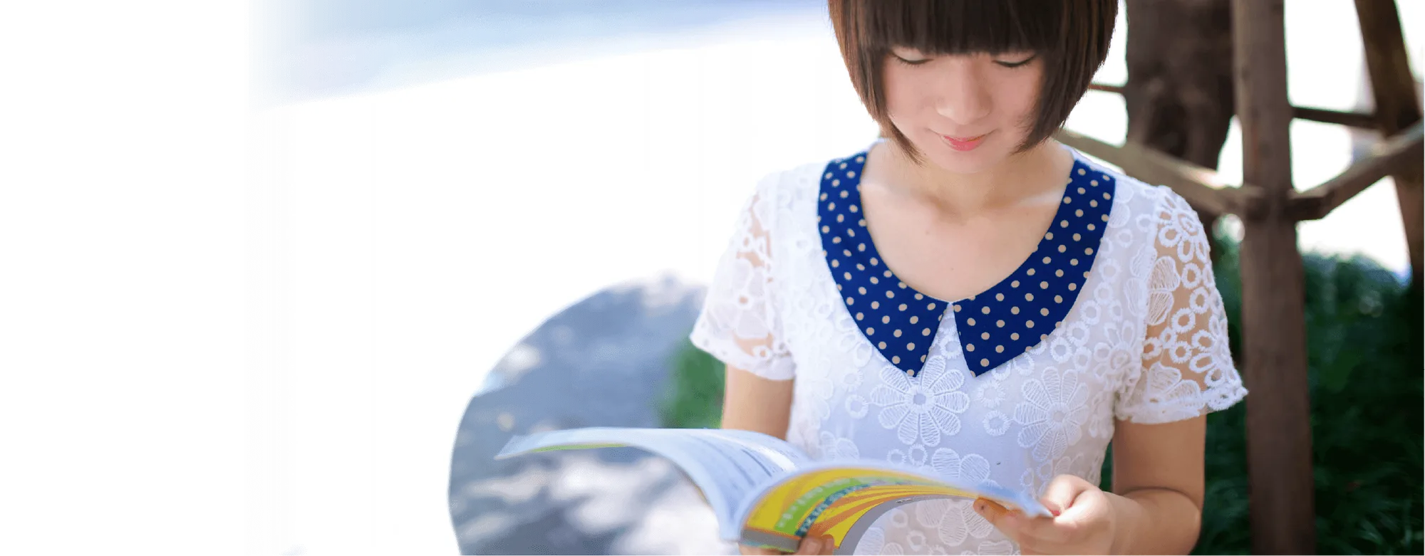 A student reading a Chinese phrasebook outdoors