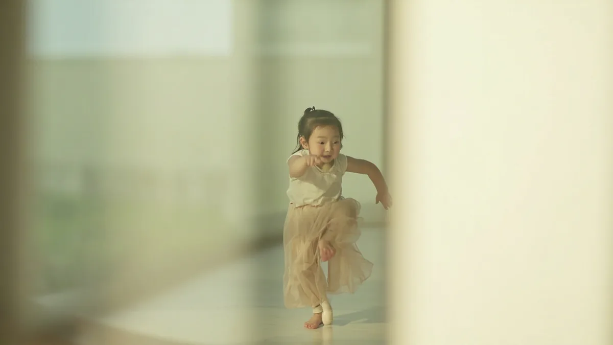 A child carefully practices a dance routine in a studio, illustrating “every move and action” in Chinese: 一举一动 (yī jǔ yī dòng)