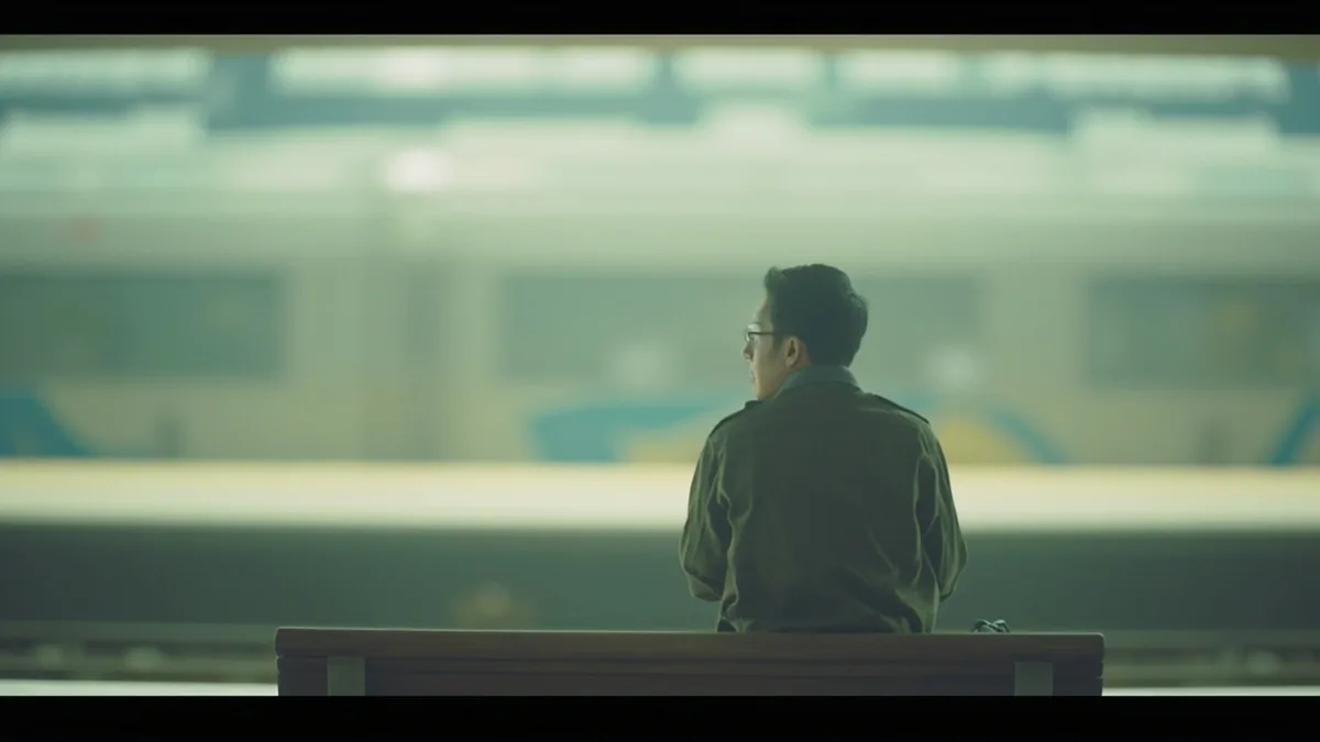 A traveler waits patiently on a bench at a quiet station platform, illustrating “hour” in Chinese: 小时 (xiǎoshi)