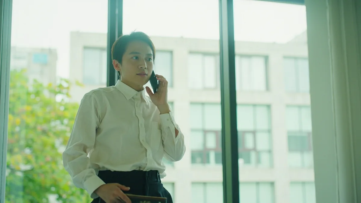 An office worker makes a phone call to request a day off from work, illustrating “I'm taking a day off” in Chinese: 我请一天假 (wǒ qǐng yī tiān jià)