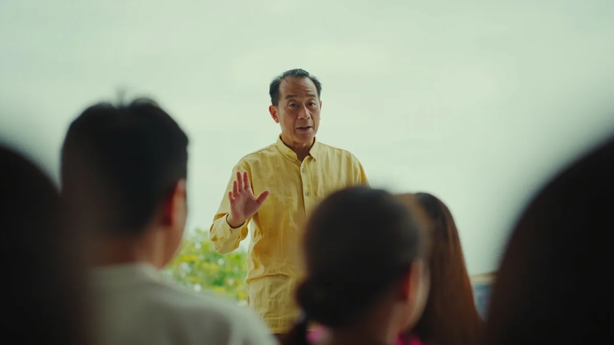 A speaker begins to introduce a topic to a small group of attentive listeners, illustrating “let me give a quick introduction” in Chinese: 我先介绍一下 (wǒ xiān jièshào yíxià)