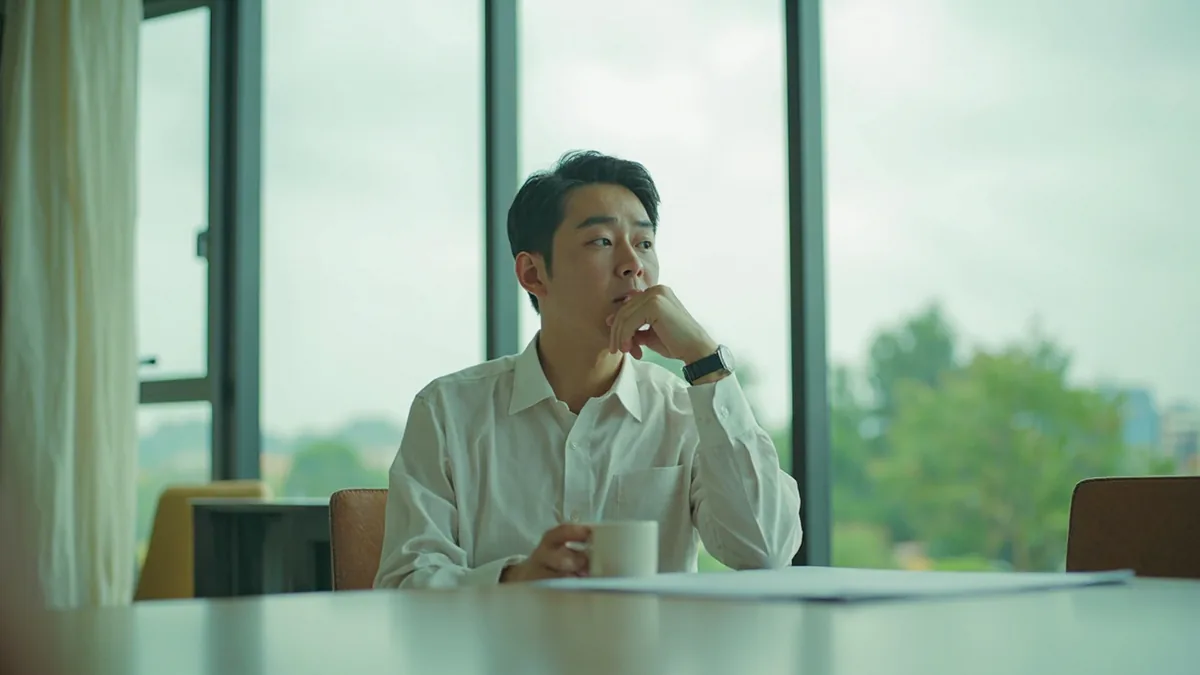 A person in a meeting considers a proposal with a thoughtful look, illustrating “let us think it over” in Chinese: 再考虑考虑 (zài kǎolǜ kǎolü)