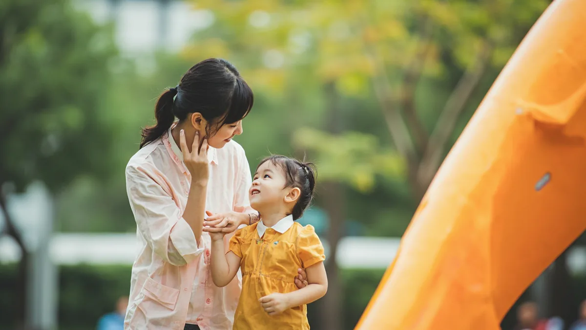 A mother gently guides her energetic child with a firm but kind look, illustrating “listen to mommy” in Chinese: 听妈妈的话 (tīng māma de huà)