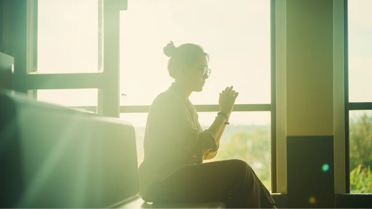 A person looks up expectantly, ready to approach after hearing a cue, illustrating “please come when your number is called” in Chinese: 叫到号请过来 (jiàodào hào qǐng guòlai)