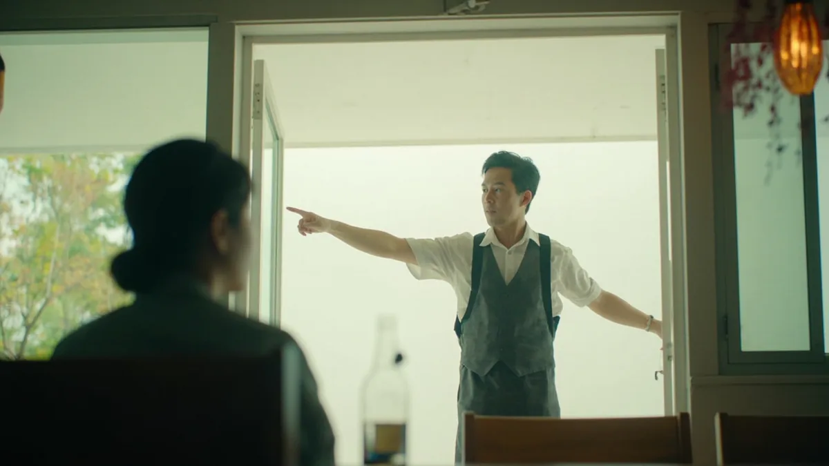 An employee gestures towards an inner passage, indicating a restroom location, illustrating “the restroom is inside” in Chinese: 洗手间在里面 (xǐshǒujiān zài lǐmiàn.)
