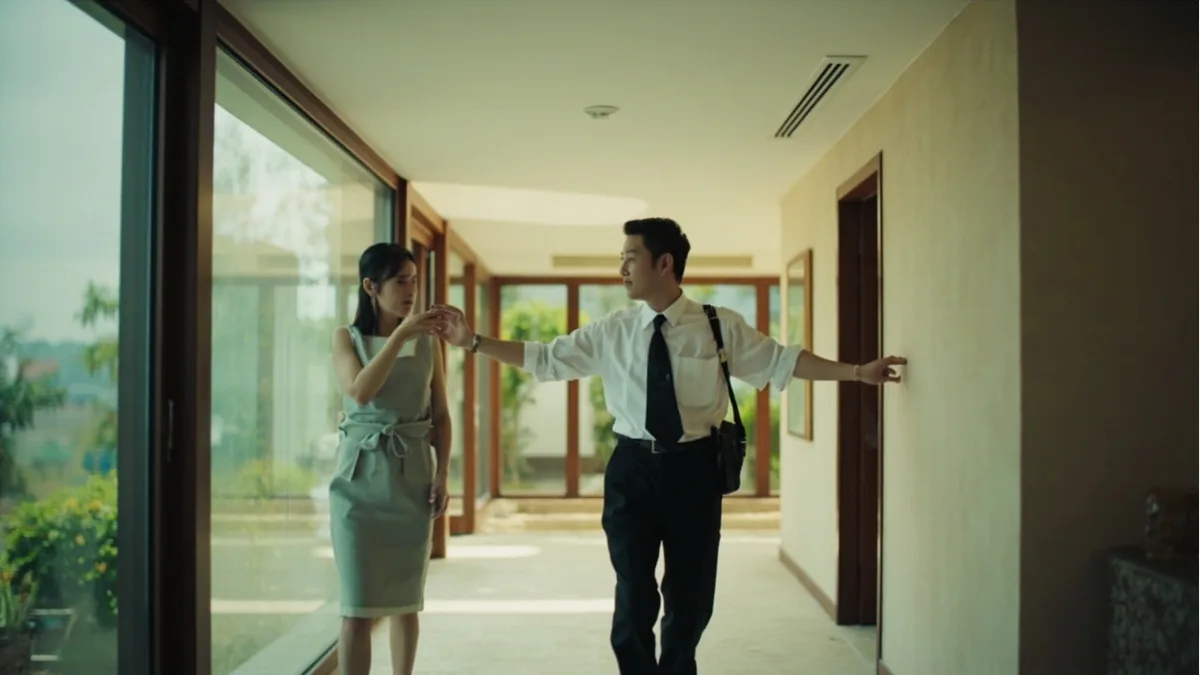 A hotel staff member gestures to guide a guest, illustrating “this way, please” in Chinese: 请这边走 (qǐng zhèbiān zǒu)